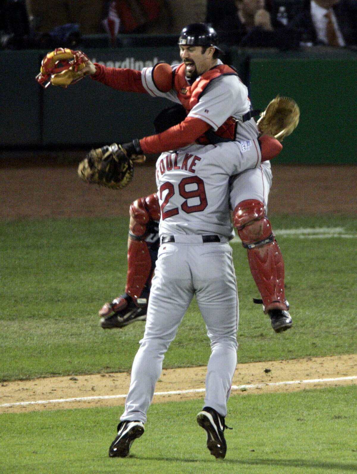 FILE - In this Oct. 27, 2004 file photo, Boston Red Sox catcher Jason Varitek leaps into the arms of pitcher Keith Foulke (29) after the Red Sox beat the St. Louis Cardinals 3-0 to sweep the World Series, in St. Louis. (AP Photo/Sue Ogrocki, File)