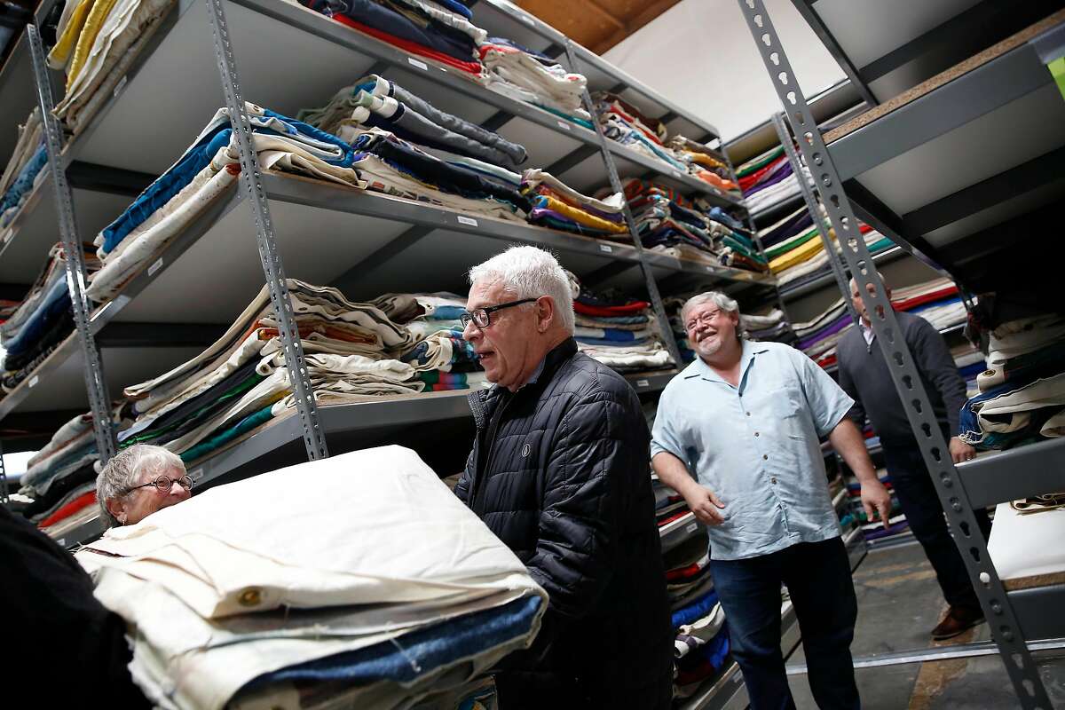 Cleve Jones (center), one of the original founders of the AIDS Memorial Quilt, carries a quilt recently arrived from Atlanta at a National AIDS Memorial Grove warehouse on Tuesday, February 18, 2020 in San Leandro, Calif.
