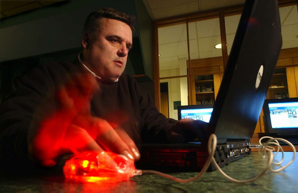 In this file photo, Rich Hanley, associate professor of journalism at Quinnipiac University, uses an optical mouse plugged into a USB port on his laptop computer. It was 2002 and the 20th anniversary of the computer mouse as a mass market consumer product.