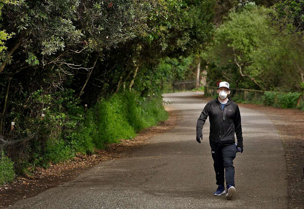 Jordan Frease, who had quadruple bypass surgery 8 months ago, walks along the Mountain Lake Trail in the Presidio in San Francisco, Calif., on Wednesday, April 8, 2020. Jordan lives alone, and is forced into further isolation as measures to prevent the spread of Covid-19 have removed him from most contact except for his required cardio walks.