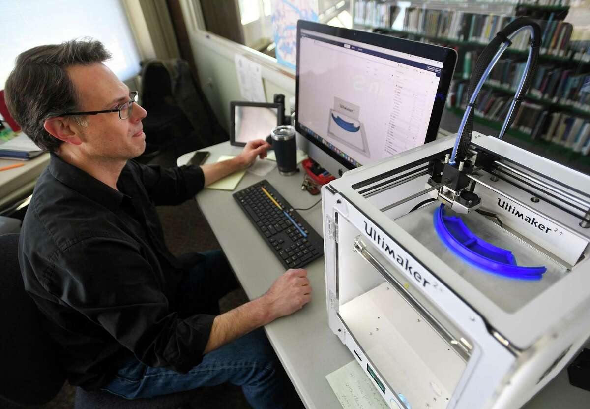 Information Systems Librarian Fred Danowski uses a 3-D printer to fashion frames for protective face shields at the Milford Library, currently closed to the public, in Milford, Conn. on Monday, April 6, 2020. Danowski produces ten of the frames each week, for use as protective equipment at St. Mary's Hospital in Waterbury.