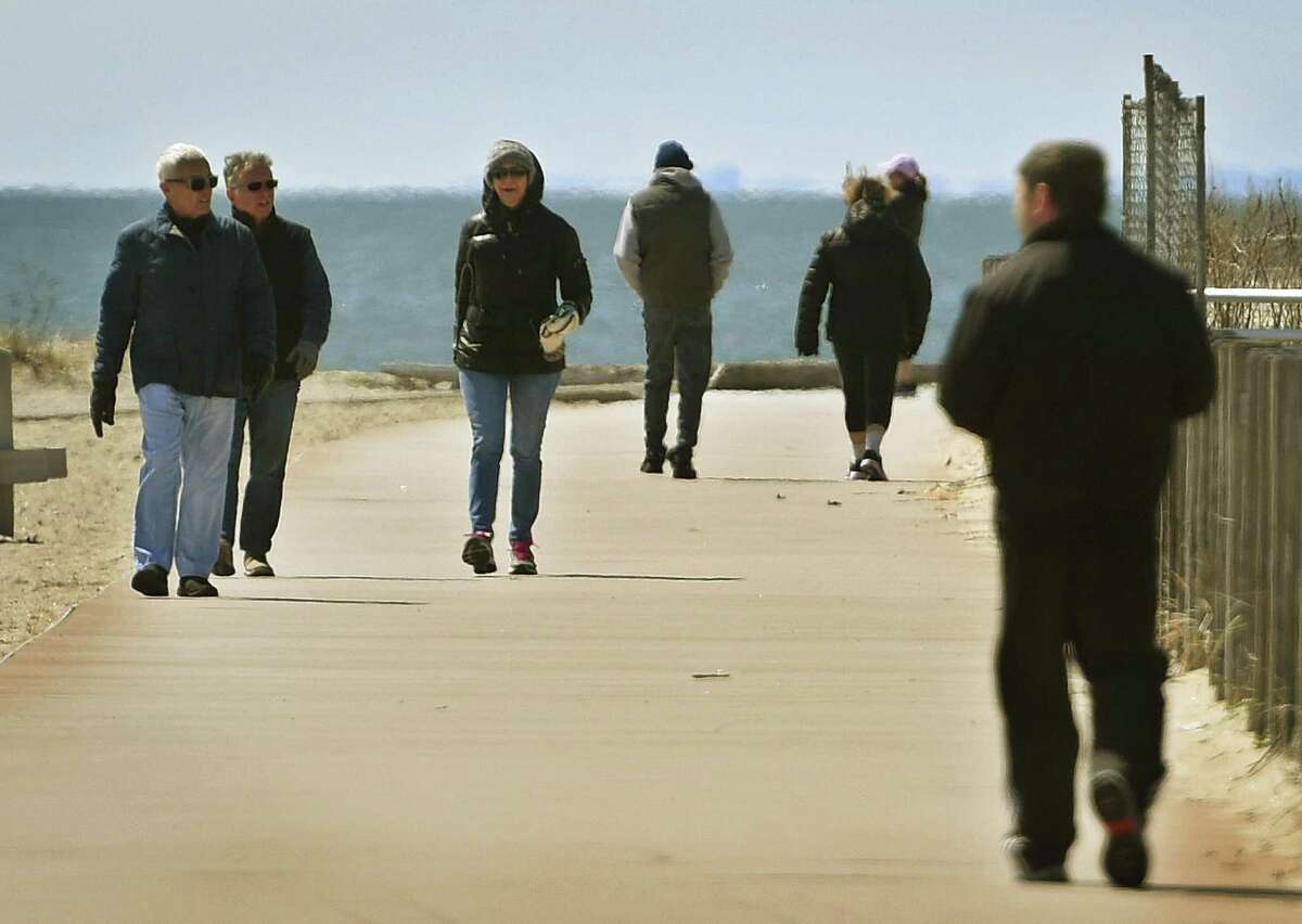 Visitors enjoy a sunny afternoon at Silver Sands State Park in Milford, Conn. on Wednesday, April 1, 2020. The Department of Energy and Environmental Protection announced plans to reduce capacity at popular parks to ensure social distancing in the wake of the coronavirus.