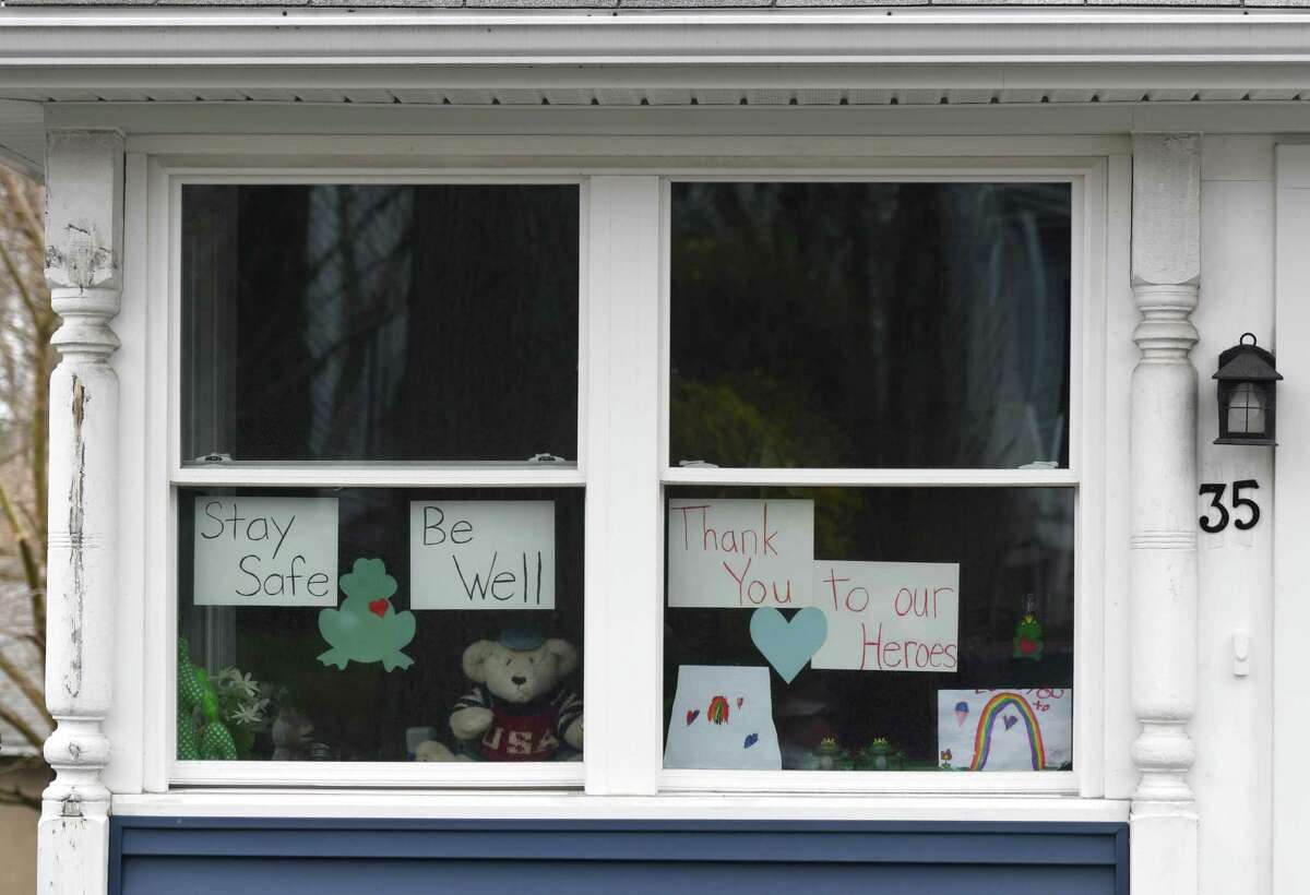 Notes of positivity are displayed in the windows of a home in the Byram section of Greenwich, Conn. Sunday, April 5, 2020. Notes of encouragement, drawings, and teddy bears are being displayed in the windows of many homes as a way to bring together community during a time of quarantine and social distancing.