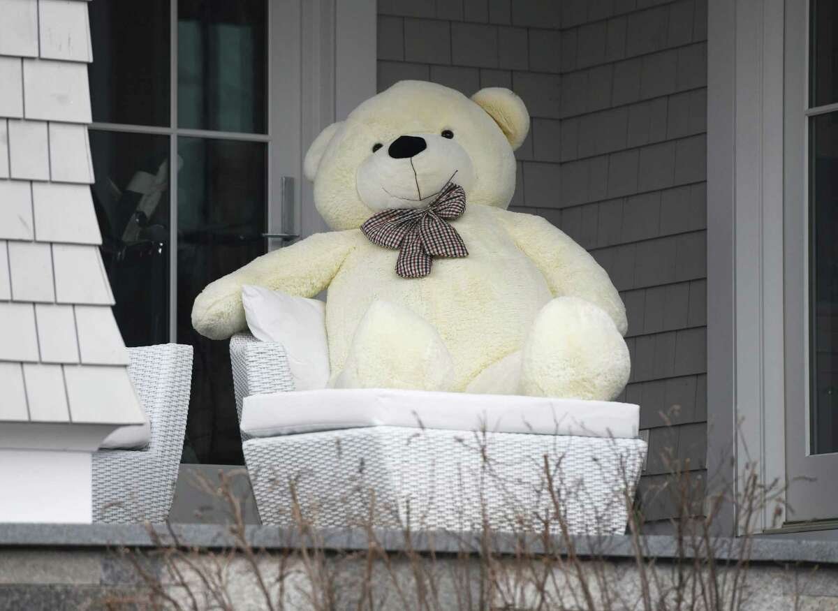 A enormous teddy bear sits on the porch of a home in Old Greenwich, Conn. Sunday, April 5, 2020. Notes of encouragement, drawings, and teddy bears are being displayed in the windows of many homes as a way to bring together community during a time of quarantine and social distancing.