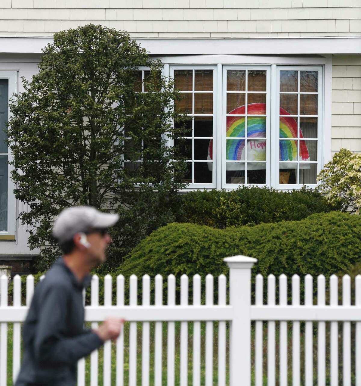 A drawing of a rainbow is displayed in the windows of a home in Old Greenwich, Conn. Sunday, April 5, 2020. Notes of encouragement, drawings, and teddy bears are being displayed in the windows of many homes as a way to bring together community during a time of quarantine and social distancing.