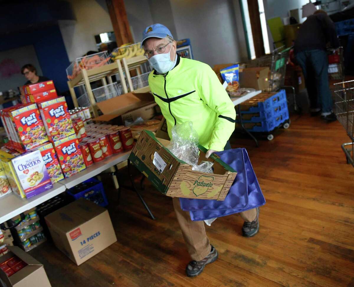 Volunteer Jim Burger works at the new temporary location of Neighbor to Neighbor's food pantry at the Arch Street Teen Center in Greenwich, Conn. Tuesday, March 31, 2020. The Neighbor to Neighbor nonprofit moved its food pantry to the Arch Street Teen Center for a larger workspace that allows for social distancing during the coronavirus outbreak.