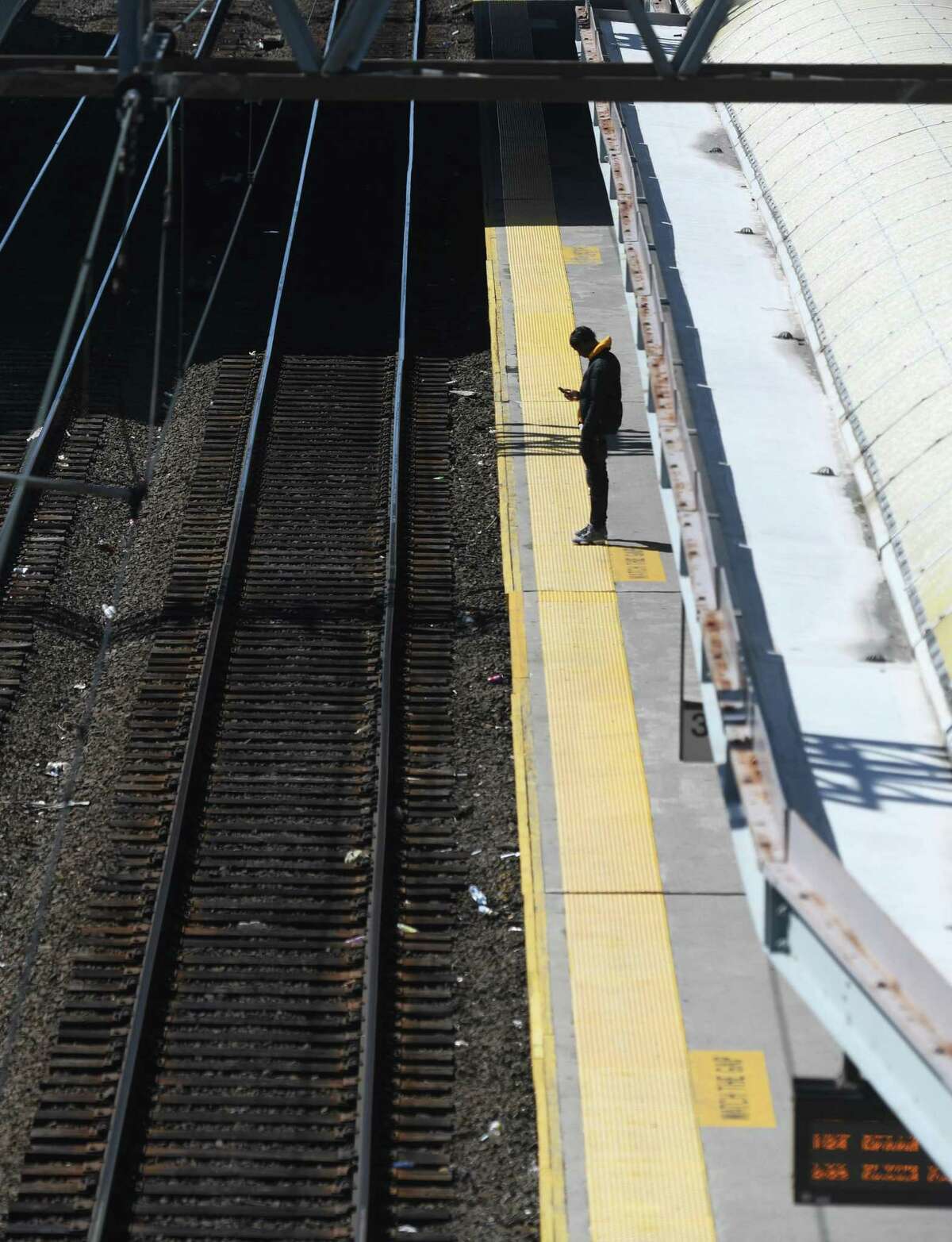 A lone traveler waits on the platform for his train at the Stamford Transportation Center in Stamford, Conn. Tuesday, March 24, 2020. Since the coronavirus outbreak, Metro-North has seen a sharp decrease in train commuters.