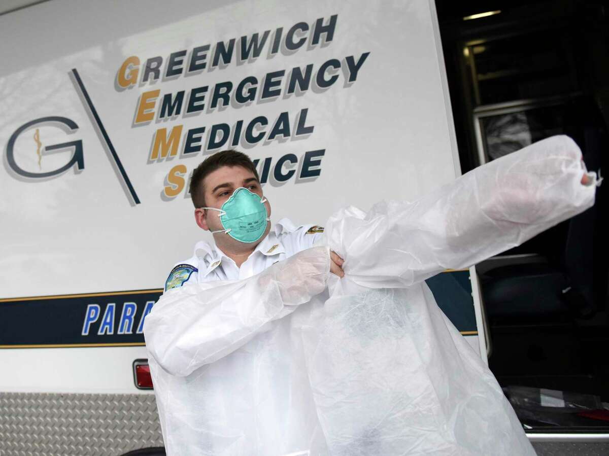 GEMS Director of Quality Assurance Colin Bassett demonstrates protective gear being implemented at the Greenwich Emergency Medical Services headquarters in the Riverside section of Greenwich, Conn. Thursday, March 19, 2020. With the coronavirus outbreak in mind, GEMS is taking new precautions including pre-screening patients for symptoms and using protective gear while responding to calls in which the patient may have symptoms or symptoms are uncertain.