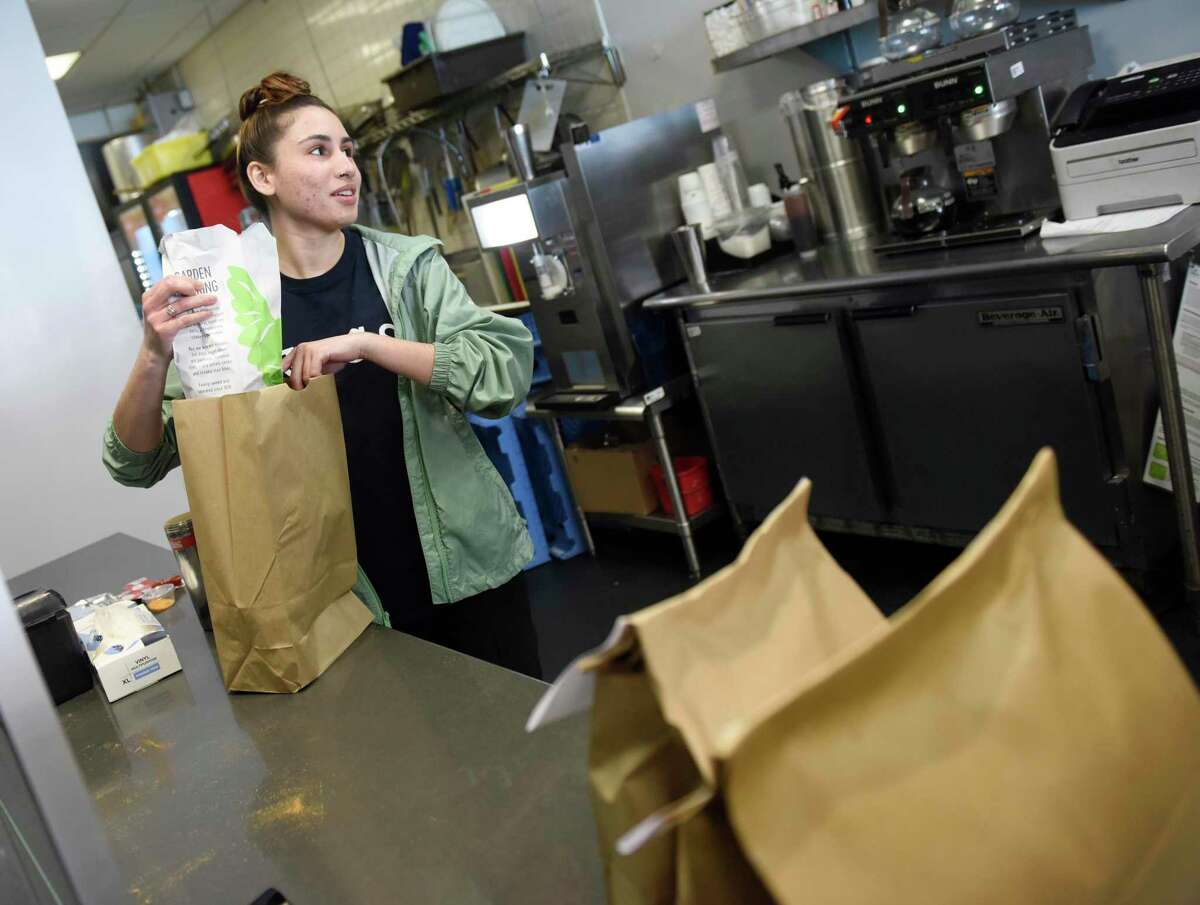 Taina Gomez puts together a take-out order at Garden Catering in Stamford, Conn. Wednesday, March 18, 2020. Restaurant dining rooms are closed amidst the coronavirus situation, but takeout and delivery are still options.