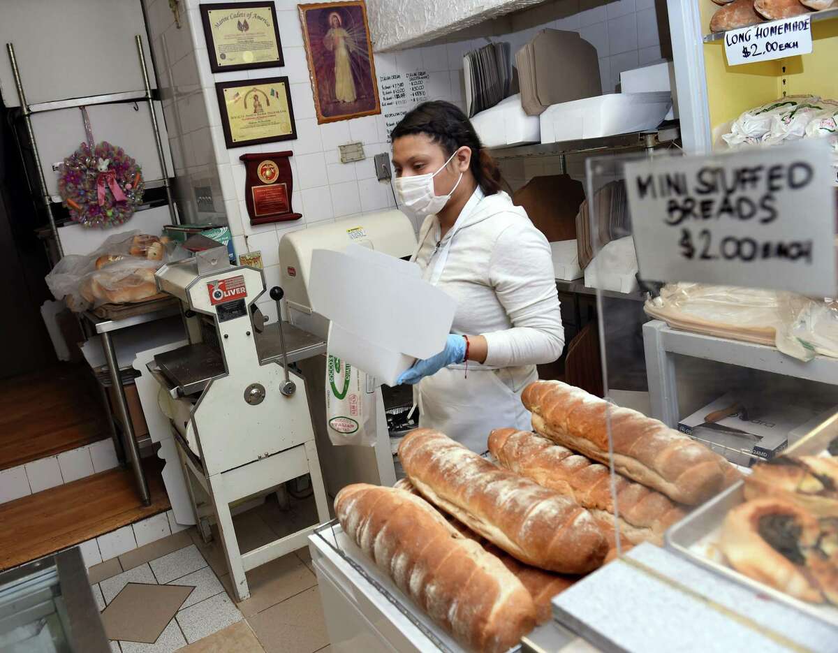 Jenizbeth Flores gathers an order for a customer at Rocco's Bakery on Ferry Street in New Haven on April 4, 2020.