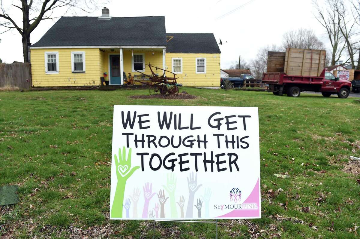 A Shelton Pink lawn sign with the words, WE WILL GET THROUGH THIS TOGETHER, is displayed on Bungay Road in Seymour on April 3, 2020.