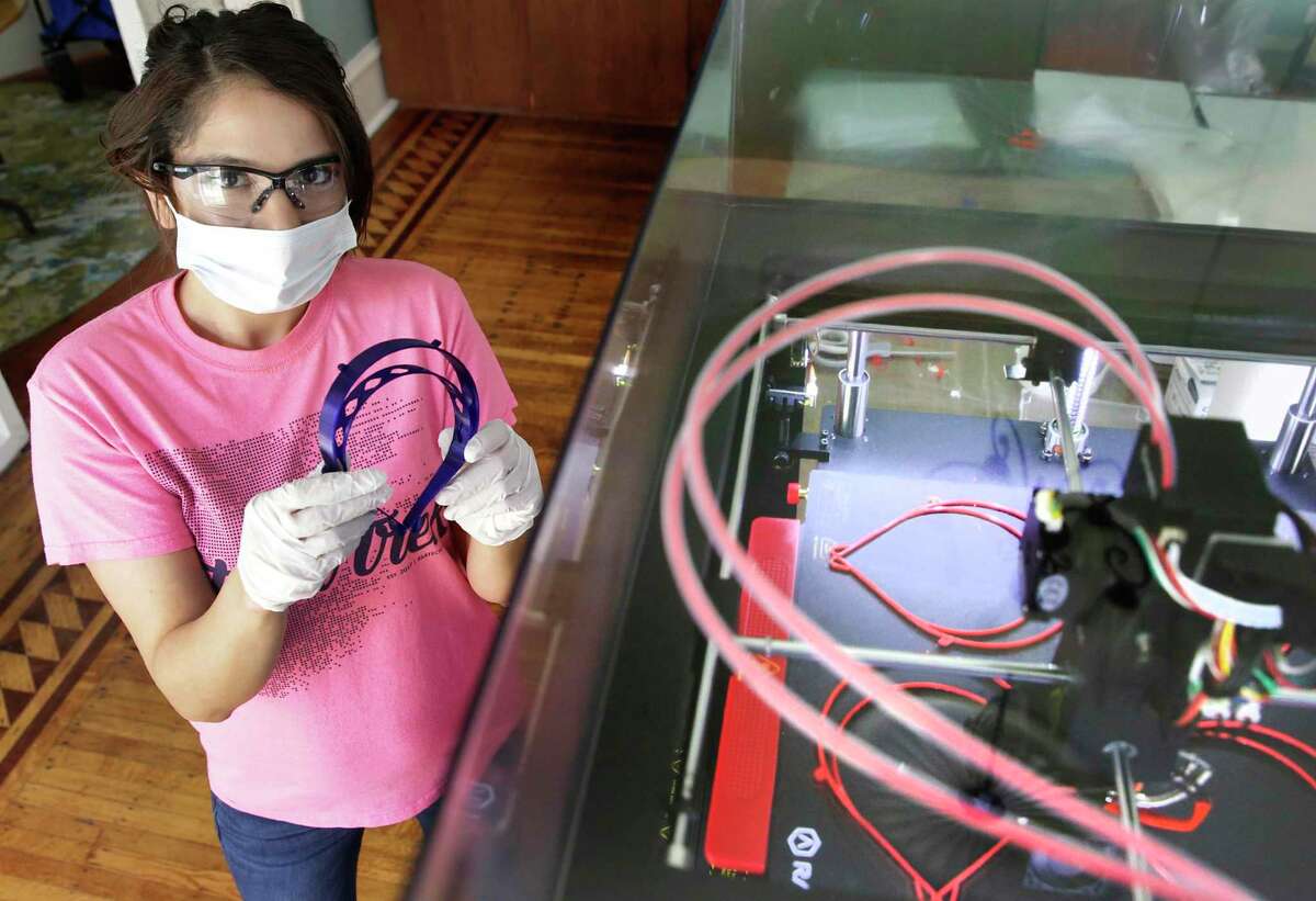 Felishia Powell, a program coordinator at Hemisfair, is among those using a 3D printer to make face shields for health workers.