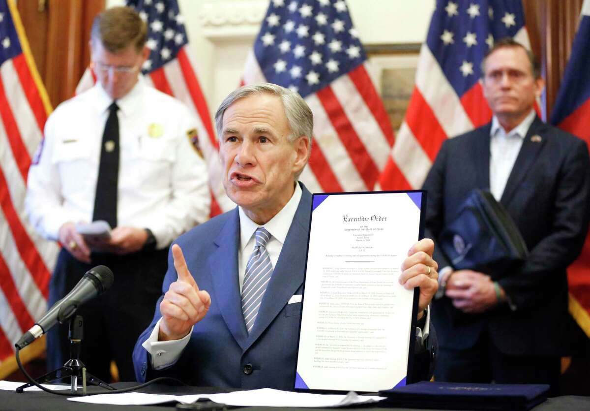 During a press conference at the Texas State Capitol in Austin, Texas Governor Greg Abbott holds a new executive order stating travel by road from any location in the state of Louisiana into Texas will require 14-day self quarantine, Sunday, March 29, 2020. He also announced the US Army Corps of Engineers and the state are putting up a 250-bed field hospital at the Kay Bailey Hutchison Convention Center in downtown Dallas The space can expand to nearly 1,400 beds. Joining him are Texas Division of Emergency Management Chief Nim Kidd (left) and former State Representative Dr. John Zerwas (right). (Tom Fox/The Dallas Morning News/Pool)