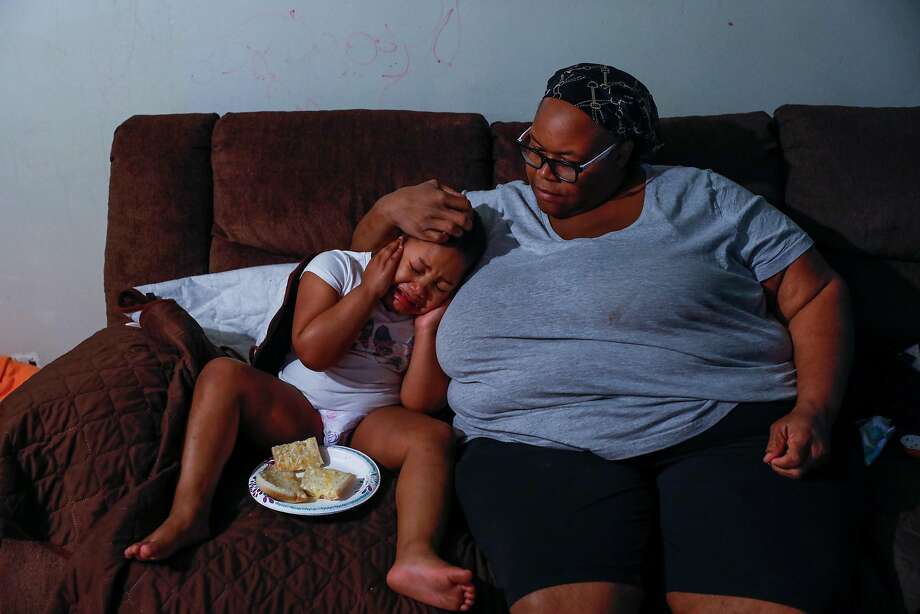 (L-r) Esther Williams consoles her daughter Miracle Smith,4, who is autistic and was upset by the noise of their new washing machine at their apartment on Sunday, April 5, 2020, in Marin City, California. Esther lost her job as a crossing guard supervisor due to Covid-19 and is worried about her finances. She takes care of her two daughters, elderly mother and her niece. Photo: Gabrielle Lurie / The Chronicle