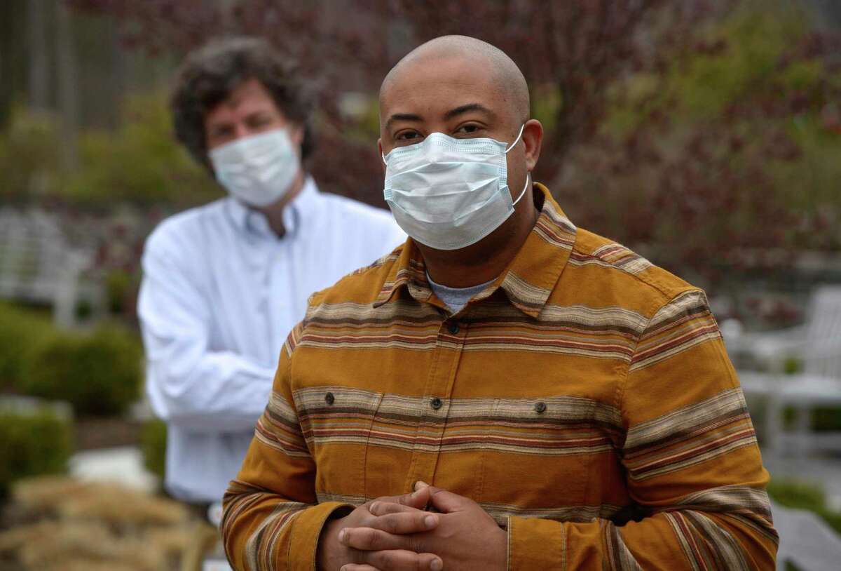 Chaplain Marlon Simpkins from the Regional Hospice in Danbury, and Sam Dexter, manager of spiritual care, behind him, have been helping nurses and social workers cope with the coronavirus. Wednesday, April 8, 2020, in Danbury, Conn.