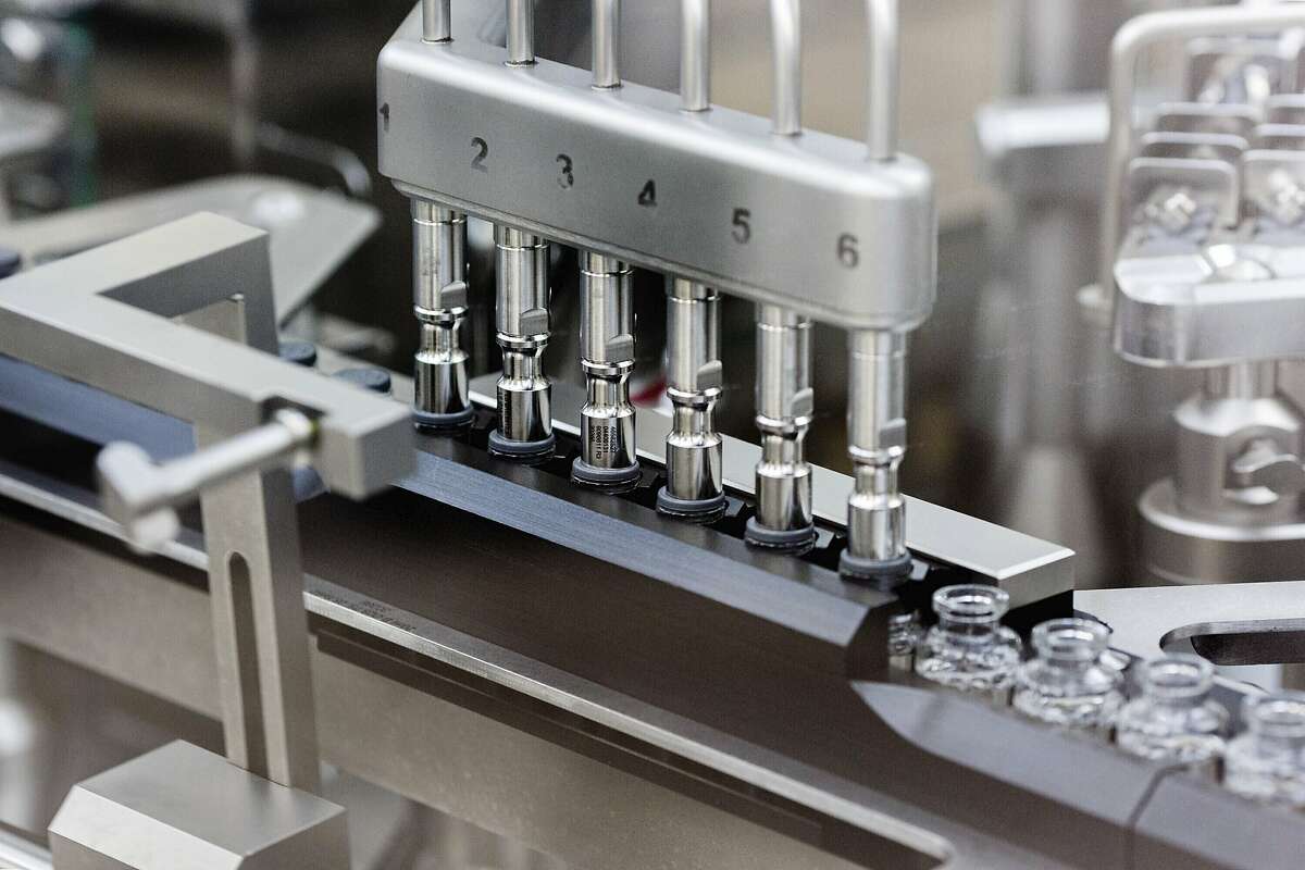 In this March 2020 photo provided by Gilead Sciences, rubber stoppers are placed onto filled vials of the investigational drug remdesivir at a Gilead manufacturing site in the United States.