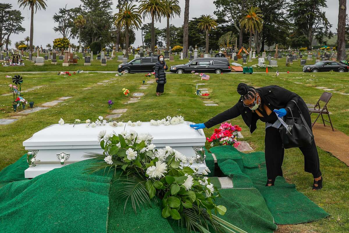 Debra Holloway prays over her mother Tessie Henry�s casket before saying goodbye to her after Covid-19 at the age of 83 is buried on Wednesday, April 8, 2020 in Colma, California.