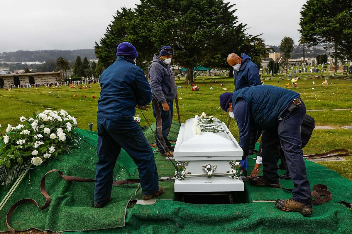Cemetery workers bury Tessie Henry who died of Covid-19 at the age of 83 is buried on Wednesday, April 8, 2020 in Colma, California.