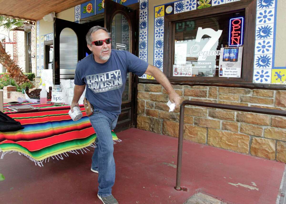 John Gerhart tosses a free roll of toilet paper he was given to his wife as part of his to-go order at 7 Leguas Mexican Restaurant, Friday, April 10, 2020, in Montgomery.