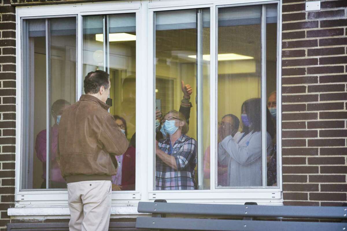 Governor Andrew Cuomo talks with staff at Pathways Nursing and Rehabilitation Center through a closed window on Sunday, April 12, 2020, in Niskayuna, N.Y. Governor Cuomo was at the center to thank them for the ventilators they loaned the state during the pandemic. (Paul Buckowski/Times Union)