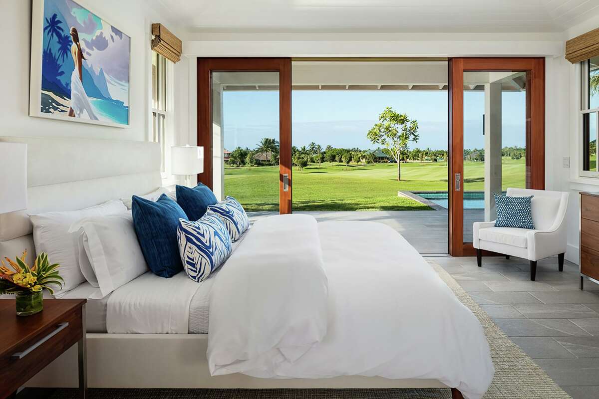 Sliding glass doors in this bedroom open to covered porch overlooking a golf course.