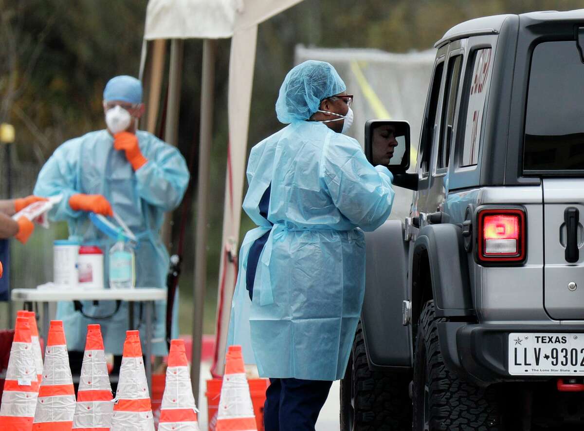 Medicals workers speak to a driver at a drive-thru coronavirus testing facility on March 16 in San Antonio. According to the World Health Organization, most people recover from the disease in about two to six weeks, depending on the severity of the illness.