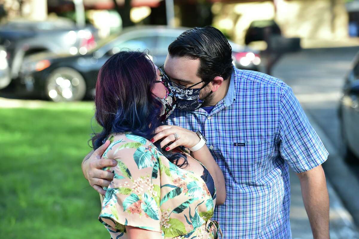 Registered nurse Natasha Gonzales gets a kiss from her husband Albert after he organized friends to drive by Sunday and wish her well as she prepares to spend 21 days in New York to help coronavirus patients.