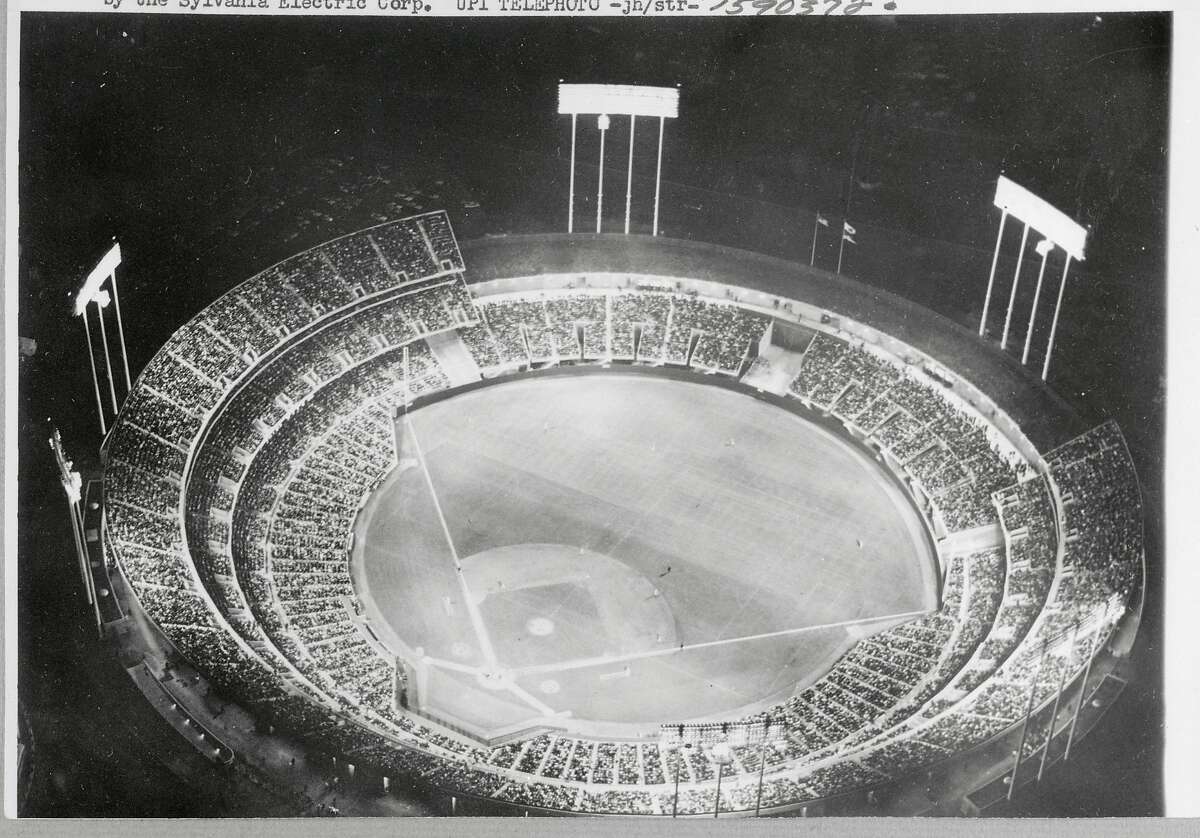 Sold out, the Oakland Alameda County Coliseum is jammed here with 50,000 fans, as play gets under way in the first baseball game ever played between the Oakland Athletics and the Baltimore Orioles. Lighting in the new ball park was installed by the Sylvania Electric Corporation.