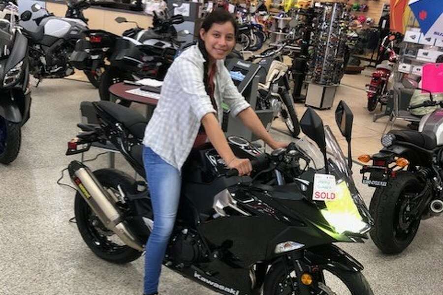 Mercedes Suarez, a local nurse, smiles with her new motorcycle that was gifted to her by Alamo Cycle Plex after the business learned her old bike was stolen. Photo: Alamo Cycle Plex