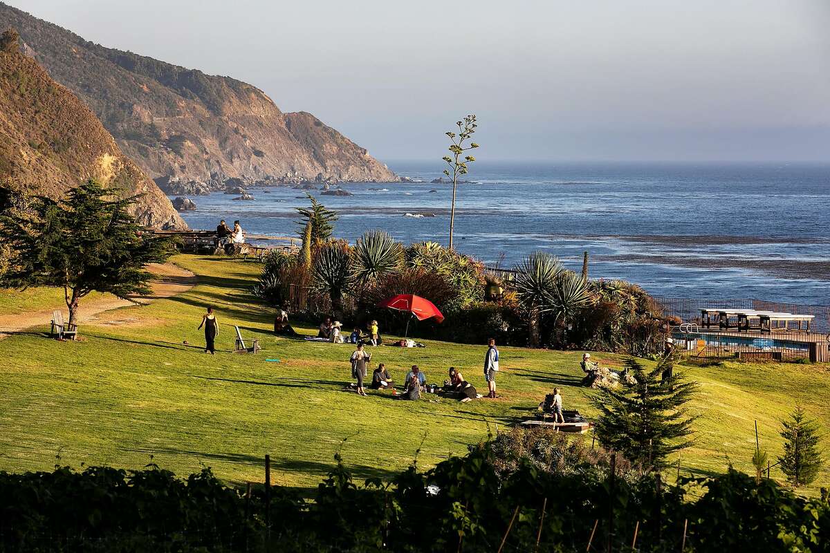 Guests relax on the lawn in front of the lodge as the sun begins to set in the late afternoon at Esalen on Friday, August 30, 2019 in Big Sur, Calif.