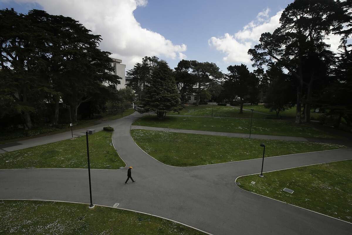 A man walks alone on a path on the San Francisco State University campus in San Francisco, Thursday, March 19, 2020. (AP Photo/Jeff Chiu)