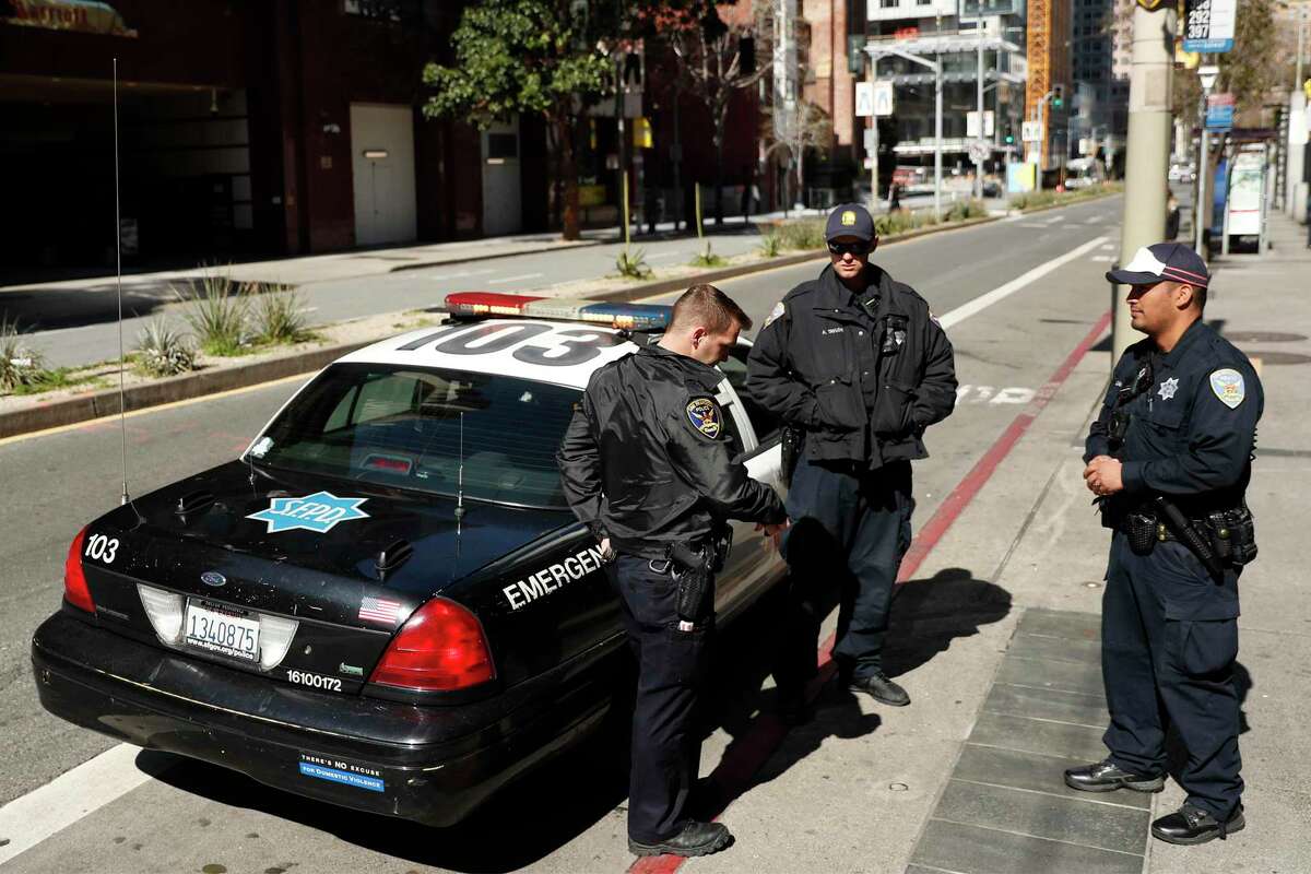 San Francisco Police officers Tyler Cope, Andre Taylor and Lazar Villalozano chat on Mission Street at 4th Street in San Francisco, Calif., on Thursday, March 26, 2020. Patrols have been more visible since the city’s stay-at-home order went into effect.