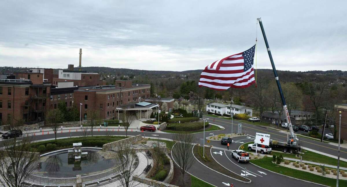 Kyle DeLucia, Owner of K&J Tree Service, and his crew set up a crane at the entrance to Danbury Hospital with a 50 foot American flag and a giant Thank You sign to show their appreciation to the hospital staff serving the community during the covid pandemic. Tuesday, April 14, 2020, in Danbury, Conn.