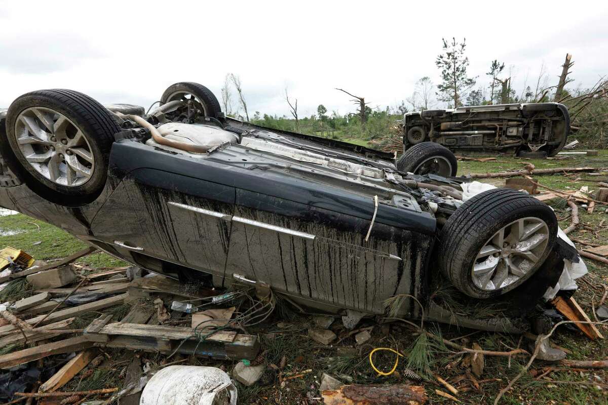 Overturned sedans rest about 100 feet from a bar and grill in a Bassfield, Miss., neighborhood  Monday. The community was one of many in Mississippi swept by a series of tornadoes, Sunday afternoon and evening.