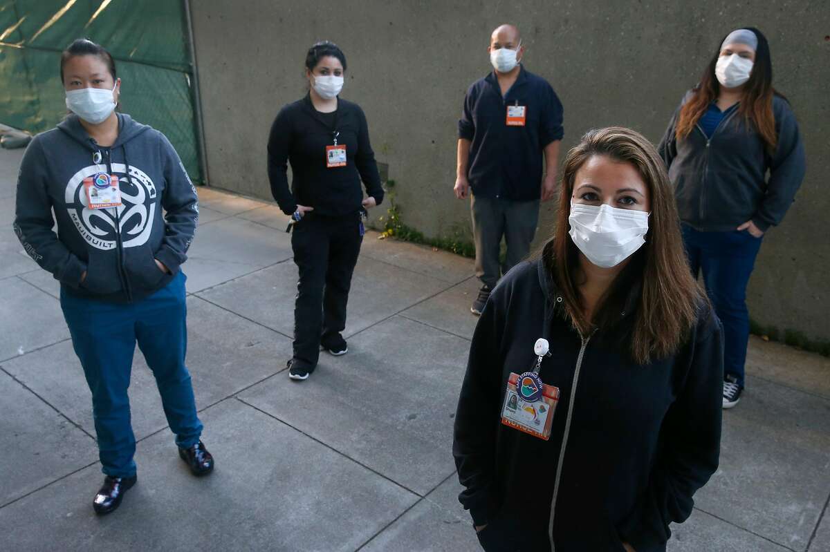 Shami Engel (foreground) gathers with colleagues outside of the psychiatric emergency department where they work as registered nurses in San Francisco, Calif. on Tuesday, April 14, 2020. Standing with Engel is, from left, Charlene Leung, Nancy Gudino, Michael Roxas and Leticia Ornelas. The nurses may have been exposed to the COVID-19 coronavirus after a patient was brought into the ward on Saturday.