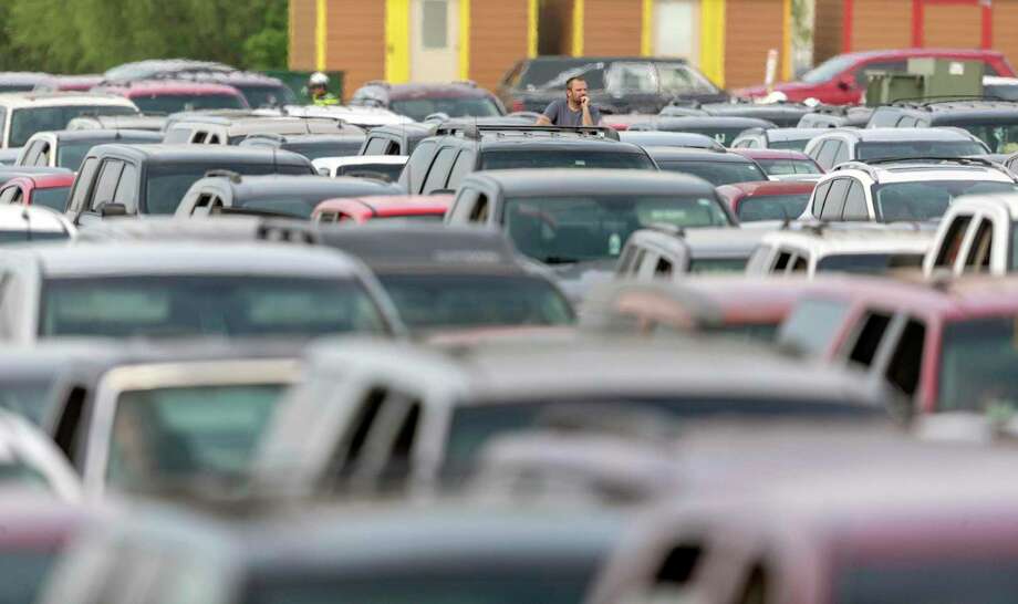 Vehicles park the parking lot at Traders Village as thousands wait for their turn for food during a distribution event organized by the San Antonio Food Bank on Thursday. Another giveaway is set for Friday at the Alamodome. Preregistration is required; go to sasfoodbank.org or call 210-431-8326. Photo: William Luther /Associated Press / ©2020 San Antonio Express-News