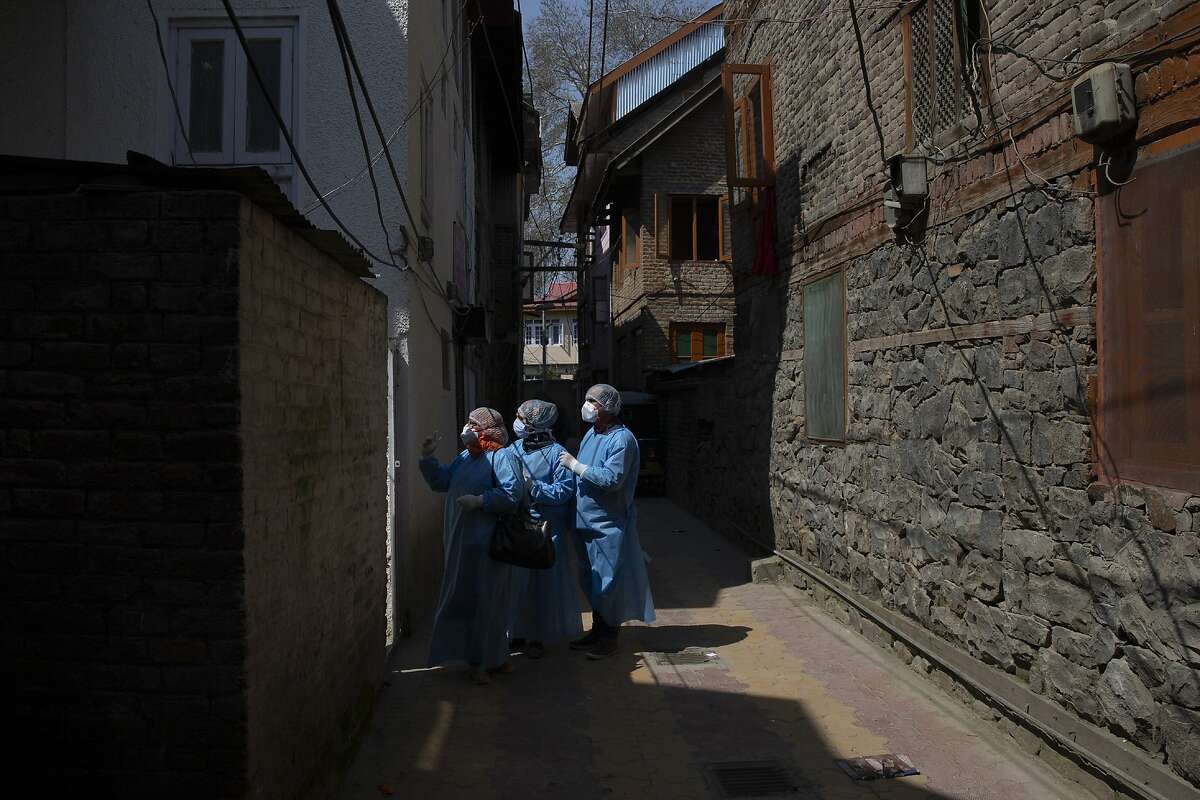 Kashmiri health workers prepares to enter a residential building during contact-tracing drive after the first person in the region was tested positive for COVID-19 in Srinagar, Indian controlled Kashmir, Thursday, March 19, 2020. For most people, the new coronavirus causes only mild or moderate symptoms. For some it can cause more severe illness. (AP Photo/ Dar Yasin)