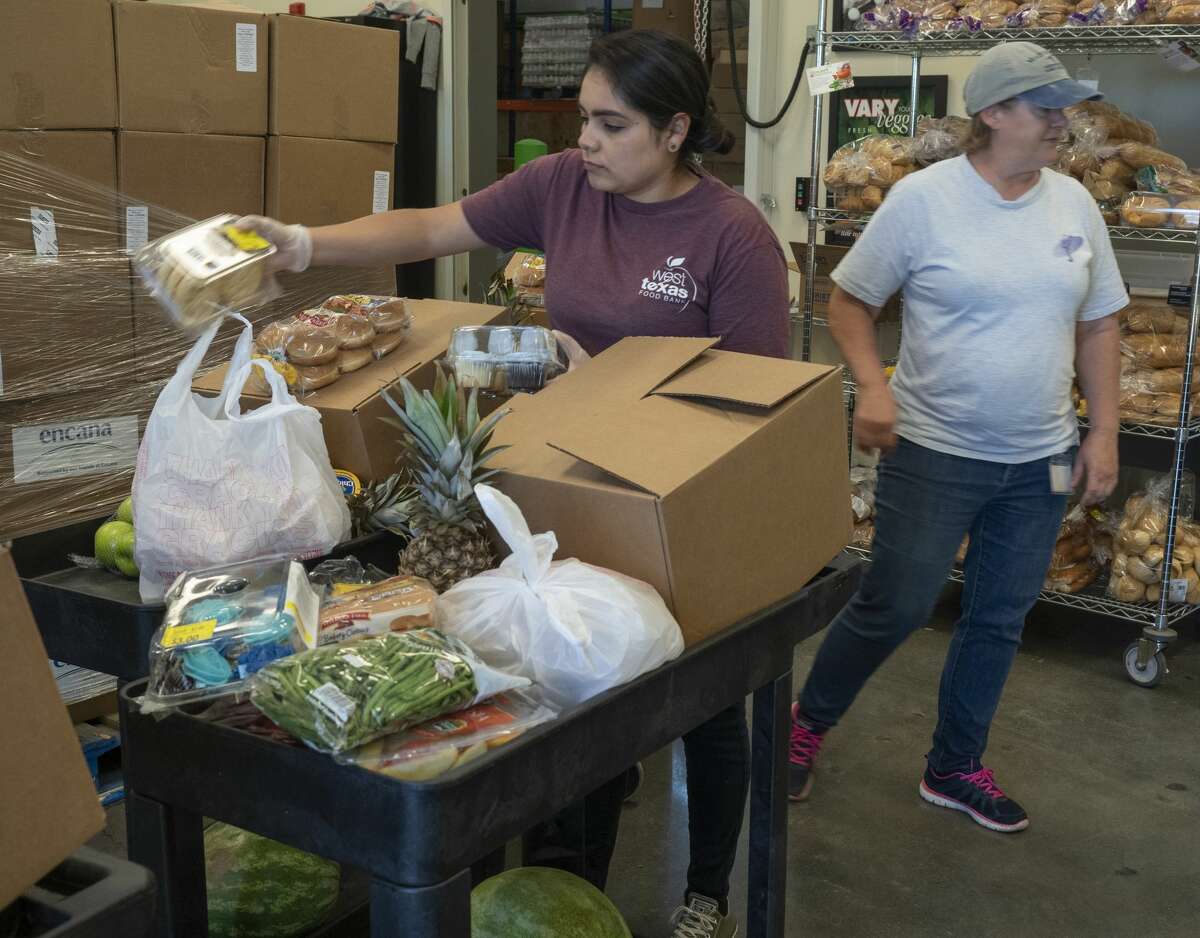 Anabel Gutierrez and Patti Edgar organize food bundles 04/15/2020 at the West Texas Food Bank in Midland for individuals and families to pick-up. Tim Fischer/Reporter-Telegram