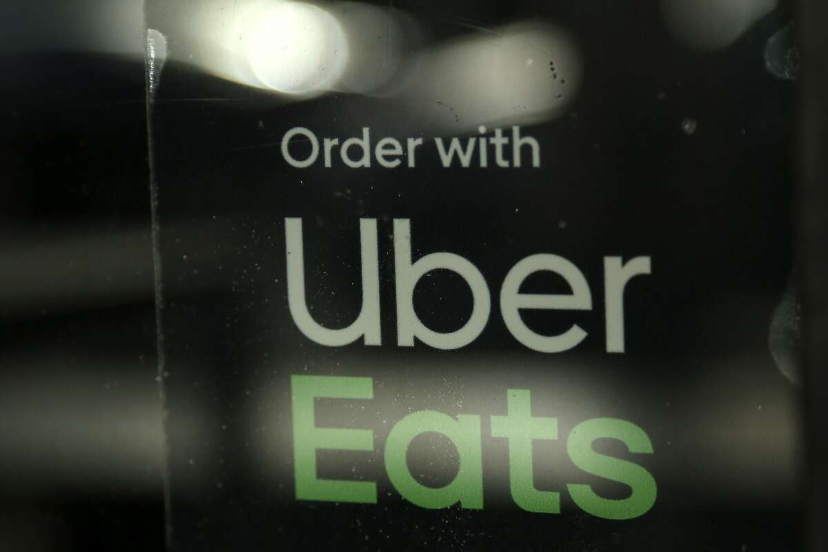 FILE - In this Nov. 6, 2019, file photo, a restaurant advertises Uber Eats in the Coconut Grove neighborhood in Miami. Some app-based delivery companies have announced hiring sprees to cope with a surge in orders from millions of people stuck at home during the coronavirus outbreak. Uber has an internal app that helps its ride-hailing drivers find work for Uber Eats and other jobs. (AP Photo/Lynne Sladky, File)