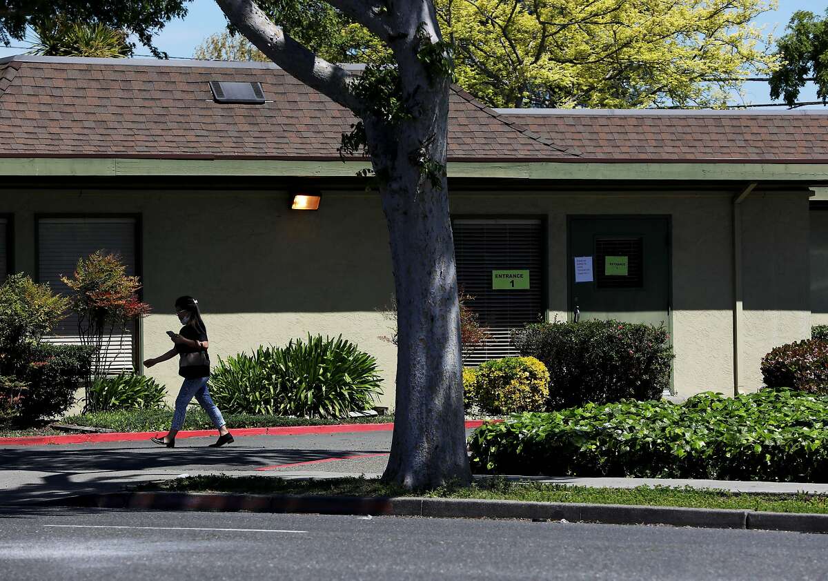 A woman leaves the Gateway Care and Rehabilitation Center, located at 26660 Patrick Ave., on Wednesday, April 15, 2020, in Hayward, Calif. The facility currently has eleven COVID-19 related deaths with dozens of staff members and patients infected with the novel coronavirus.