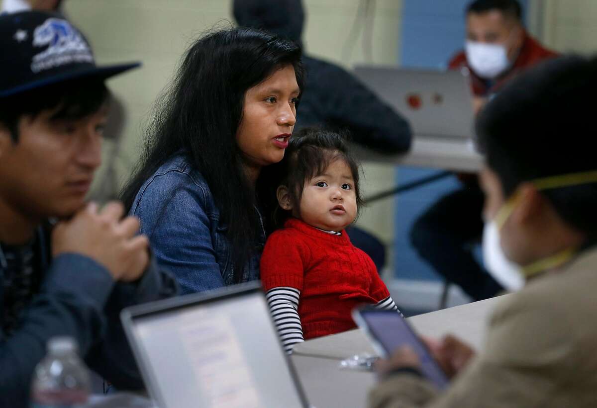 Odilia Ramirez and her daughter Keyli Garcia, 1, meets with a volunteer at a U.S. census count focused on residents who speak Mam, an indigenous Mayan language spoken by hundreds in the community, in Oakland, Calif. on Saturday, April 11, 2020.