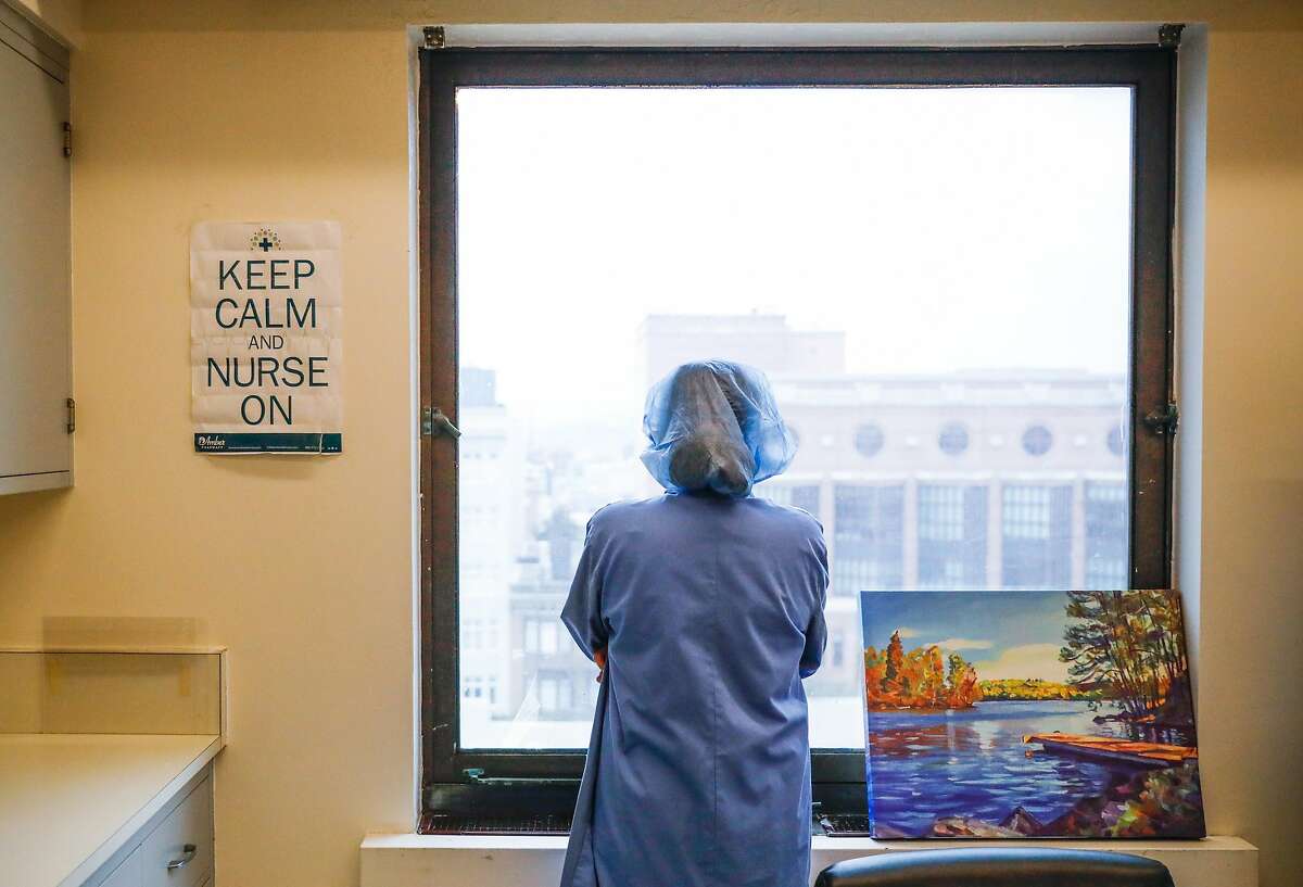 Supervising nurse Regina Truong looks out the window as she takes a break at the Covid-19 floor at Saint Francis Hospital in San Francisco on Monday, April 6, 2020.
