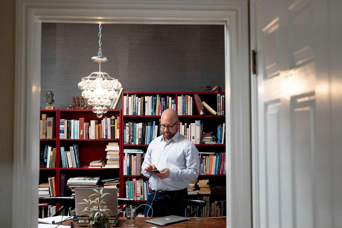 San Francisco District 8 Supervisor Rafael Mandelman checks his phone while working from his home in San Francisco, Calif. Thursday, April 9, 2020.in San Francisco, Calif. Thursday, April 9, 2020.