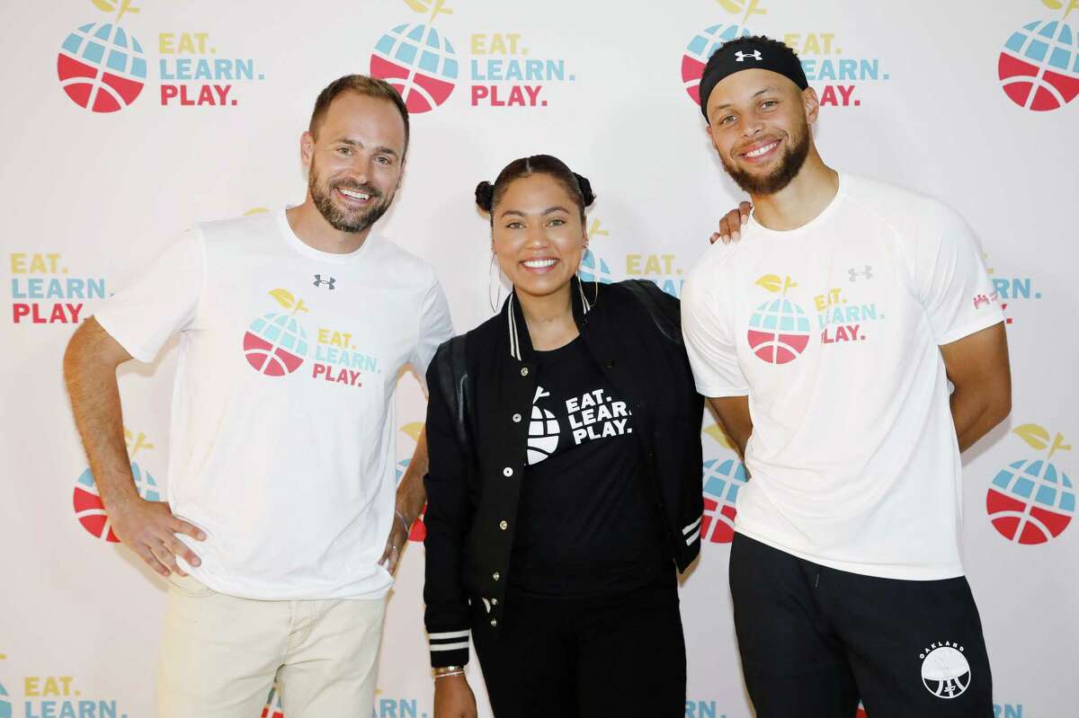 OAKLAND, CALIFORNIA - JULY 18: (L-R) Chris Helfrich, Ayesha Curry and Stephen Curry are seen at the launch of Eat. Learn. Play. Foundation on July 18, 2019 in Oakland, California. (Photo by Kimberly White/Getty Images for for Eat. Learn. Play.)