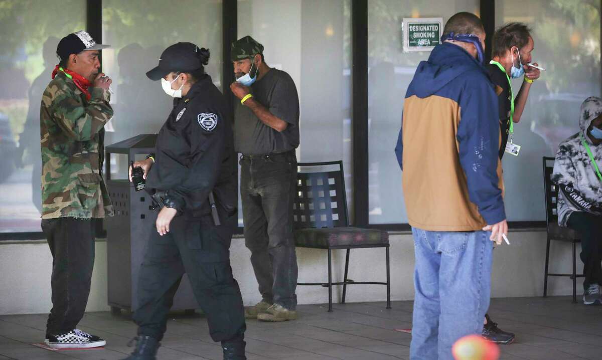 The City of San Antonio and Haven for Hope are using the Holiday Inn Hotel building located at 318 W. Cesar Chavez Blvd. to house some of the homeless, on Wednesday, April 15, 2020. A security guard walks by the smoking area.