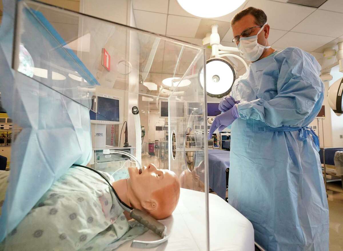 Dr. Faisal Masud, director of the Critical Care Center at Houston Methodist, demonstrates the Houston Methodist Aerosol Container, a clear plastic box-like device that shields clinicians from expelled air when intubating a patient amid the COVID-19 pandemic shown Wednesday, April 15, 2020.