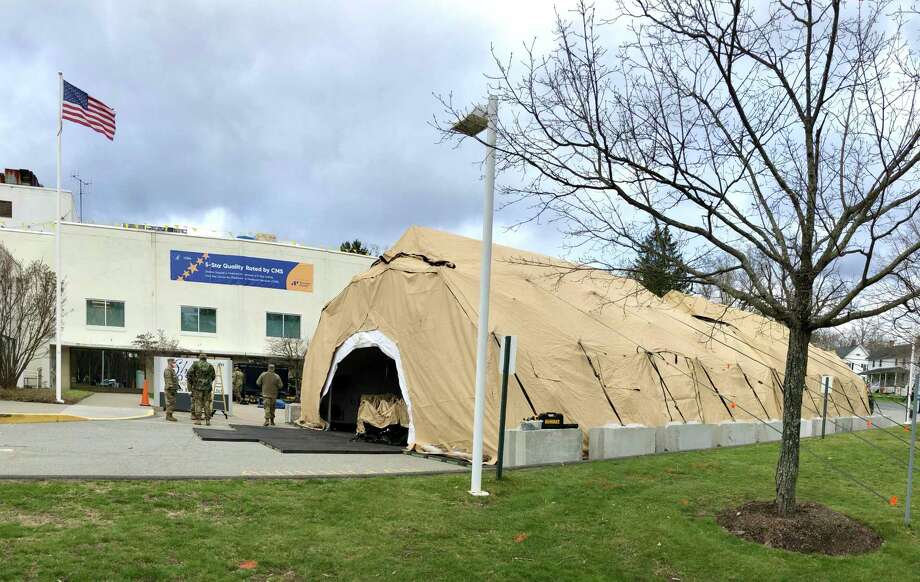Members of Governor Ned Lamont’s Foot Guard and Horse Guard, along with the Connecticut National Guard, construct a 25-bed mobile field hospital on the campus of Sharon Hospital April 10. Photo: Sharon Hospital / Contributed Photo