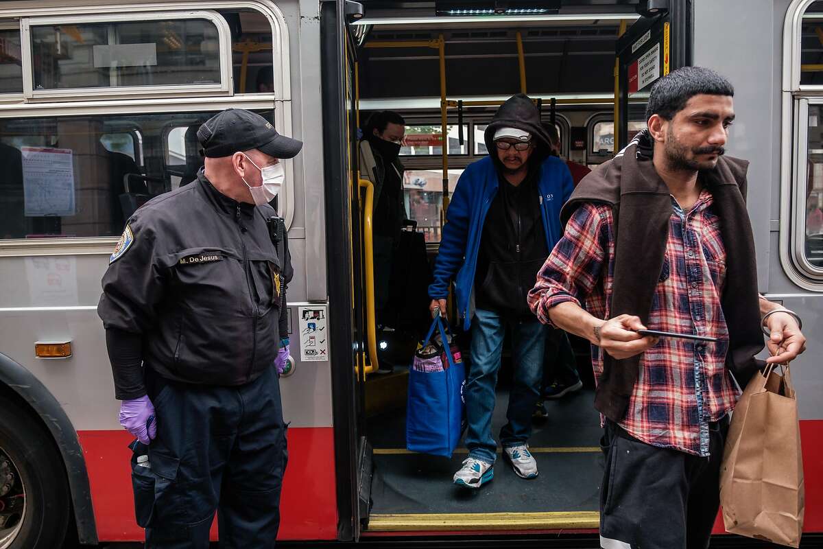 MTA traffic fair inspector Mark DeJesus checks a bus for occupancy, social distancing, and number of people wearing masks on a bus in San Francisco, Calif. on Thursday April 16, 2020.