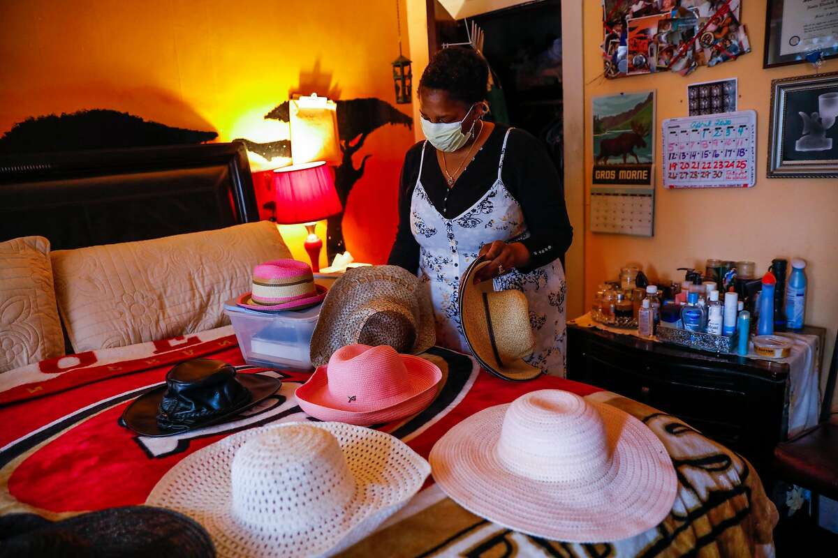 Natalie Henry Berry the daughter of Tessie Henry who died of Covid-19 at the age of 83 looks through her mothers collection of hats on Saturday, April 11, 2020 in San Francisco, California.