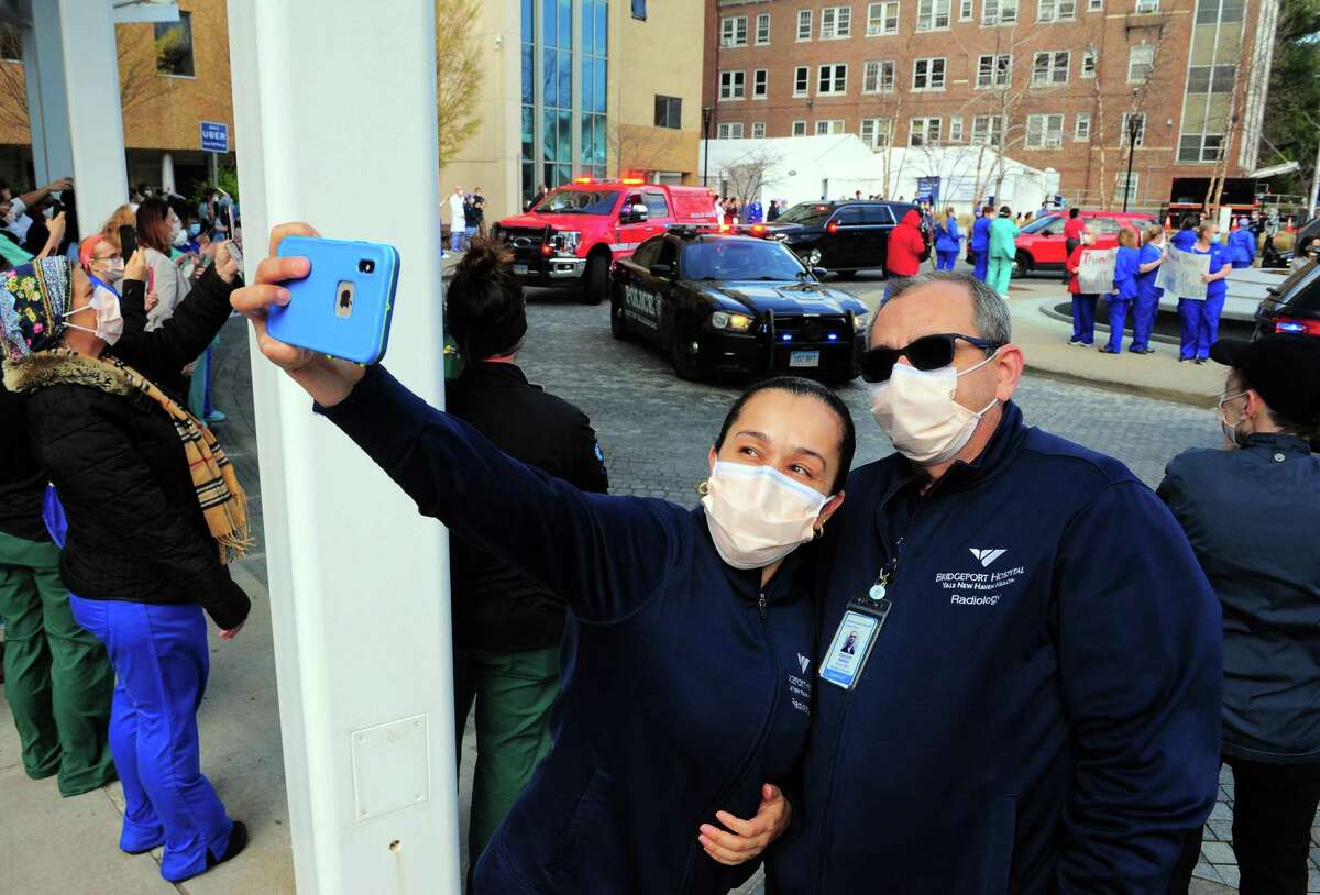 Bridgeport Hostpital health care worker Andrea Munera snaps a selfie with Giancarlo Galasso as dozens of first responders arrive to thank them for their hard work in fighting the coronavirus in Bridgeport, Conn., on Thursday Apr. 16, 2020.